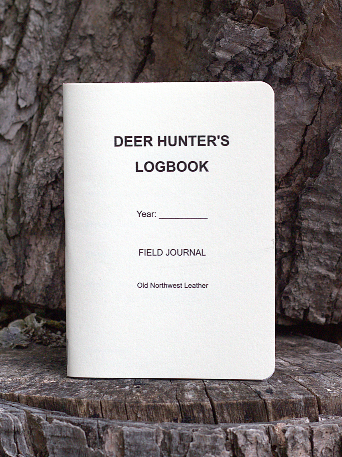 A deer hunting journal made in central Wisconsin standing upright on a wooden background. Made by Old Northwest Leather.