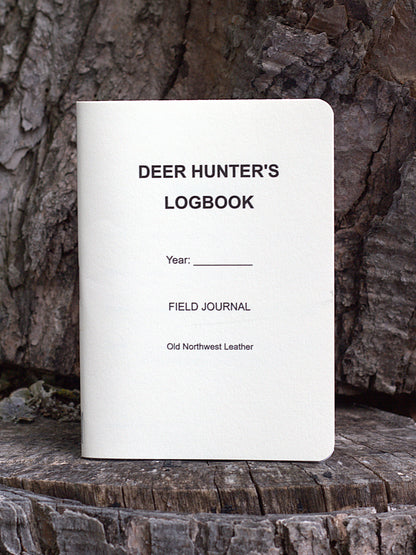 A deer hunting journal made in central Wisconsin standing upright on a wooden background. Made by Old Northwest Leather.